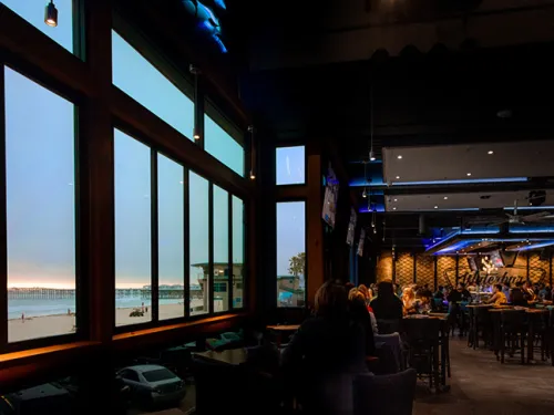 People dining inside during sunset at Waterbar in Pacific Beach of San Diego, CA