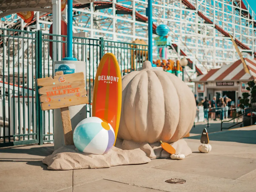 Fall decorations sitting in front of the Giant Dipper at Belmont Park in San Diego on Mission Beach