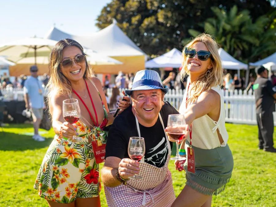 Three people cheersing on the lawn at the San Diego Food and Wine Festival