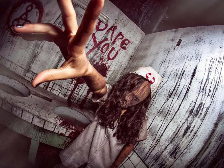 A haunted house employee, a zombie nurse grabbing for the camera on the haunted trails in San Diego