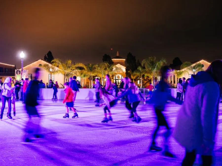 A group of people skating at night on an outdoor ice rink at Liberty Station in San Diego.