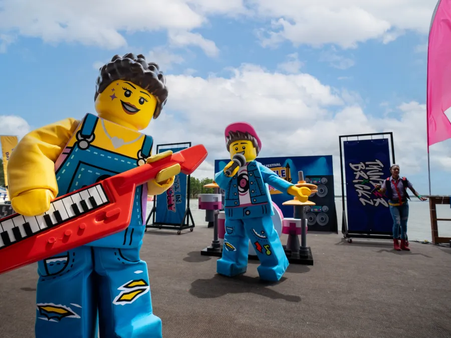 Lego figures performing with instruments on a vibrant outdoor stage at LEGOLAND California.