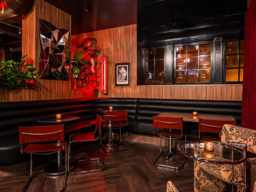 The Diamond Room featuring a stylish bar interior with wooden walls, cozy seating, and warm lighting.