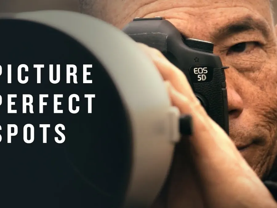A man looks through the viewfinder of a professional camera with the words "Picture Perfect Spots" displayed beside him.