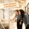 Two women admire a display case containing bones, engaged and curious in a bright setting.